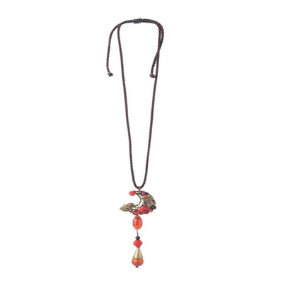 Stunning silver fish pendant on black thread with a vibrant blue ball. - TMV_NP4